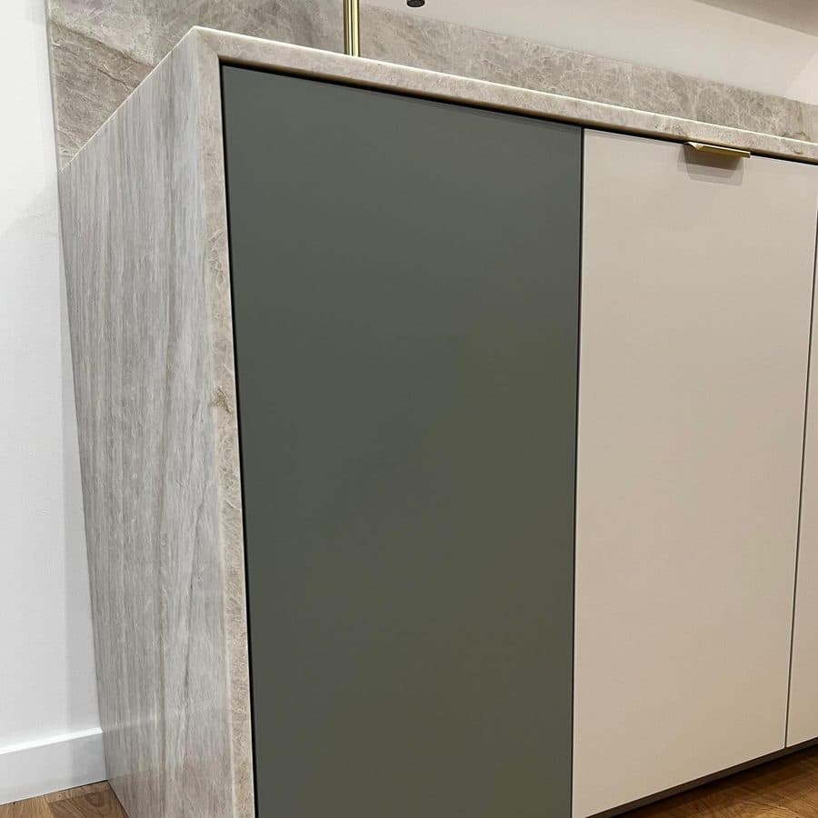 Façade en mat anti-traces vert de gris clipsée sur la cuisine du showroom