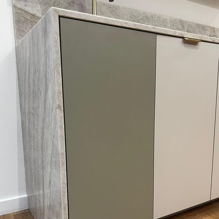Façade en mélaminé vert sauge clipsée sur la cuisine du showroom